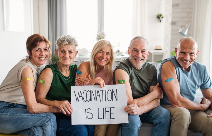 Group of older adults holding a sign that says "Vaccination is Life."