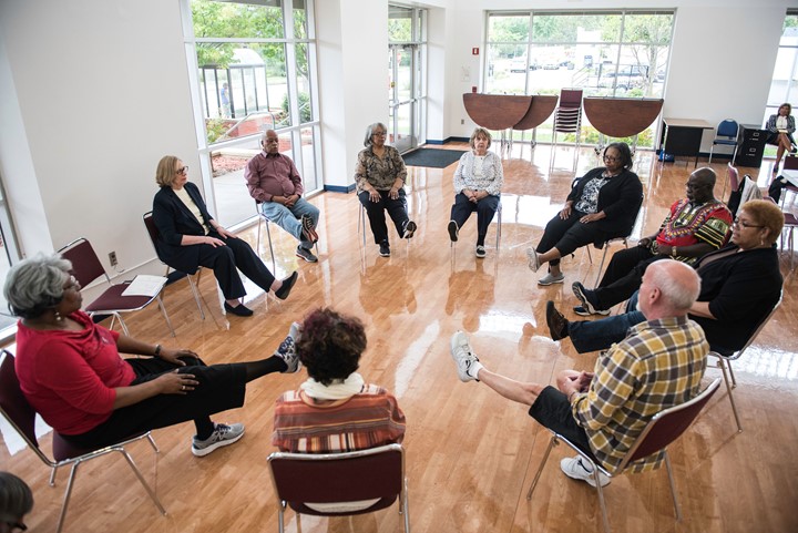 Group of older adults in a class doing exercises.