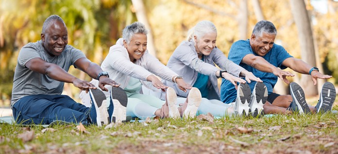 A photo of four people stretching outdoors