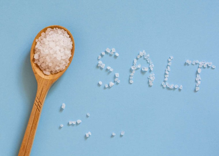 A spoon full of salt with the word "salt" spelled out with salt