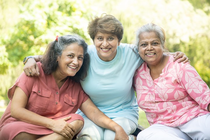 Three Hispanic women sitting together and smiling