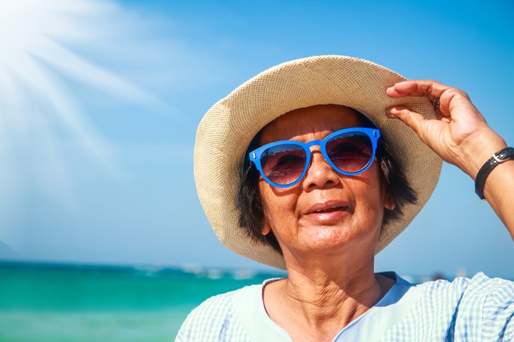 Older woman in the sun with a hat and sunglasses on