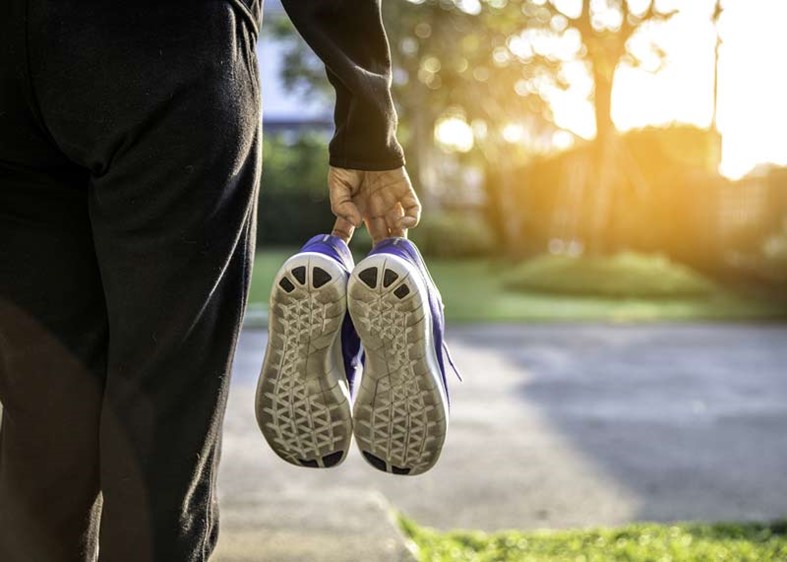 woman holding athletic shoes