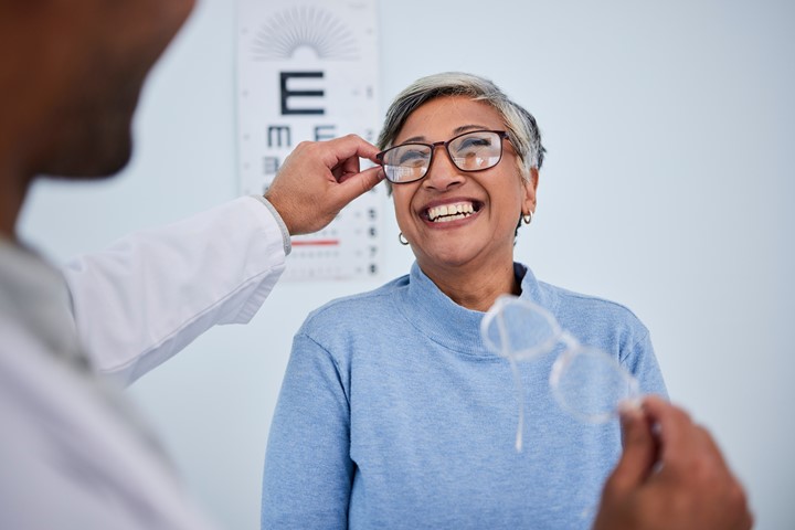 Older woman at an eye exam trying on glasses