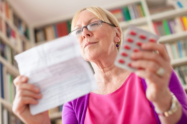 Older adult woman looking at prescription instructions