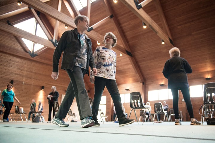 Two people walking together indoors.