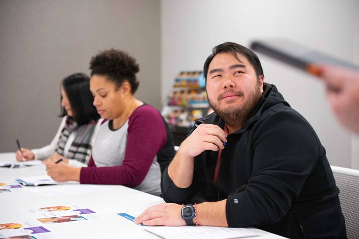 Photo of three people in a classroom.