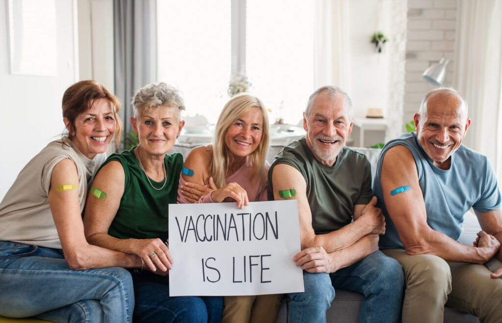 Group of older adults holding a sign that says "Vaccination is Life."