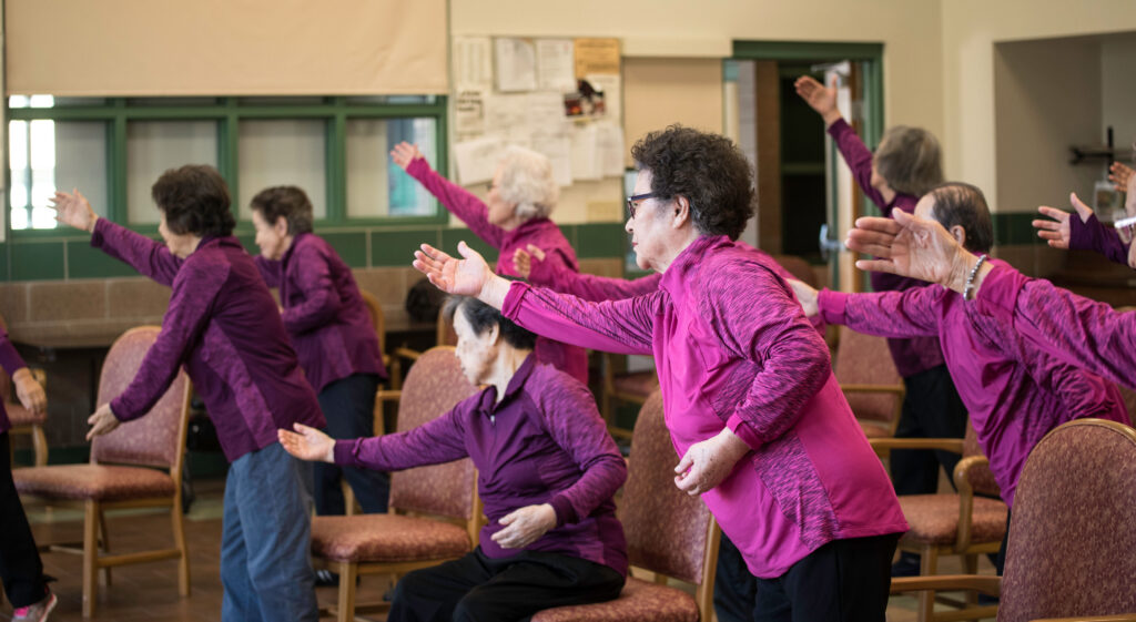 Photo of a group of people doing tai ji quan poses.